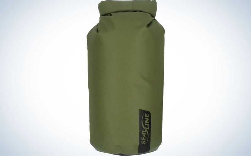 A large bag similar to a boxing bag which is green and in the shape of a cylinder.