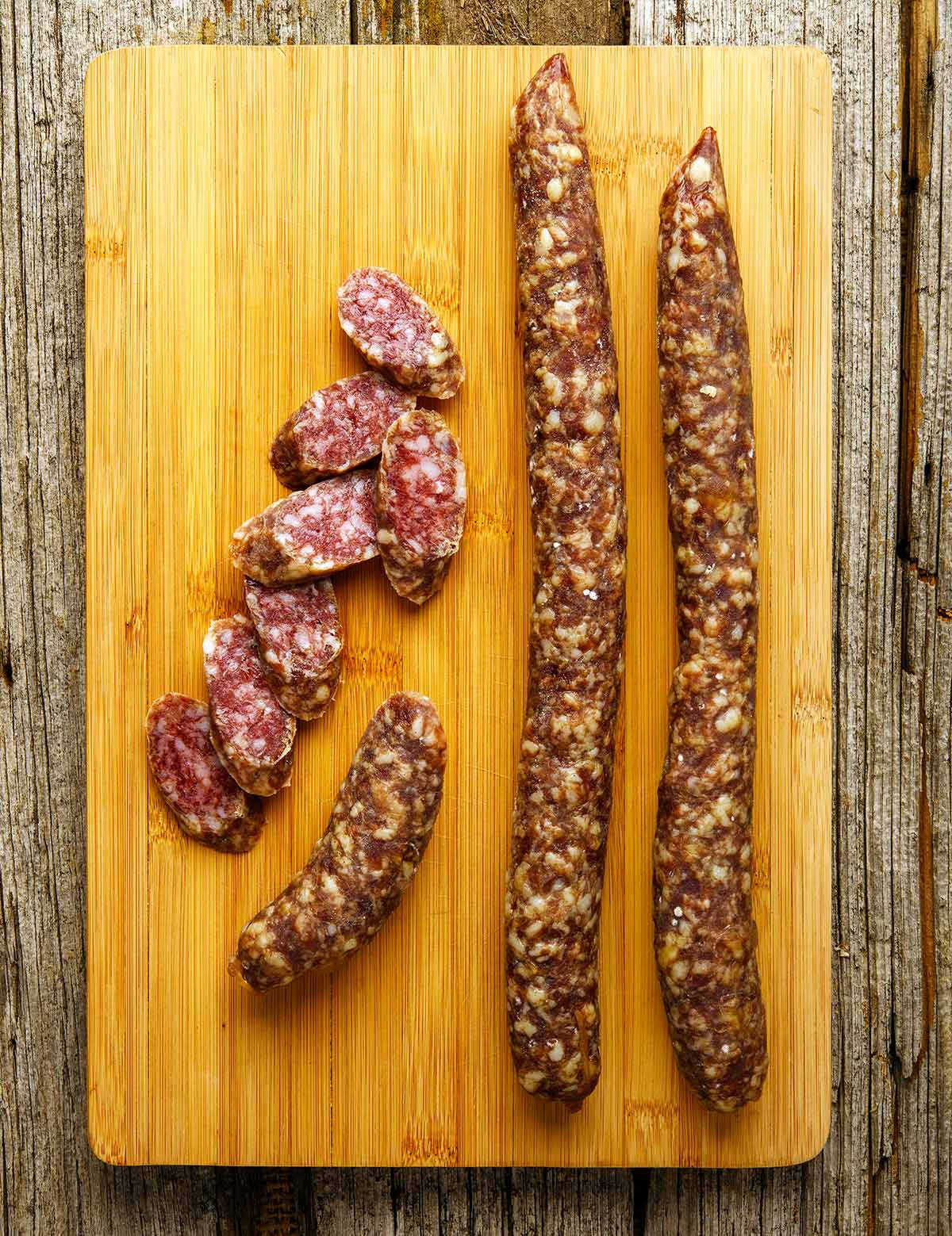 Lengths of fuet on a cutting board.