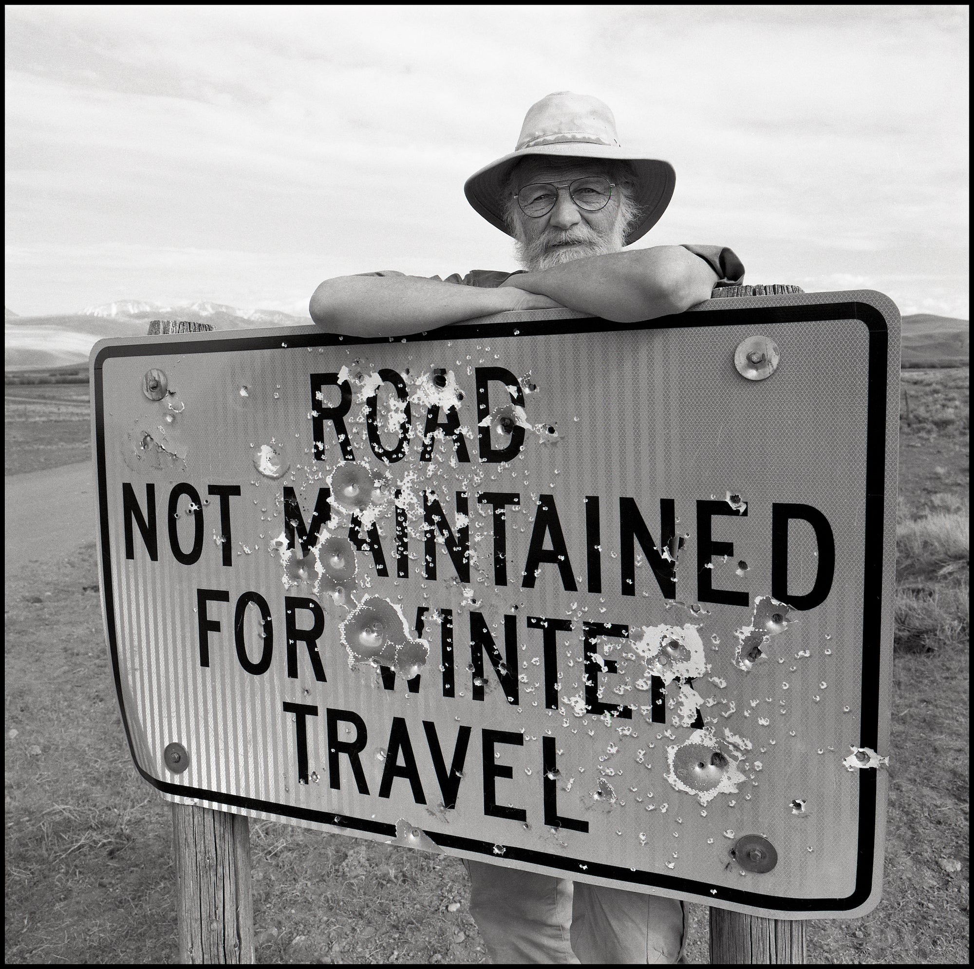John Gierach standing next to a sign.