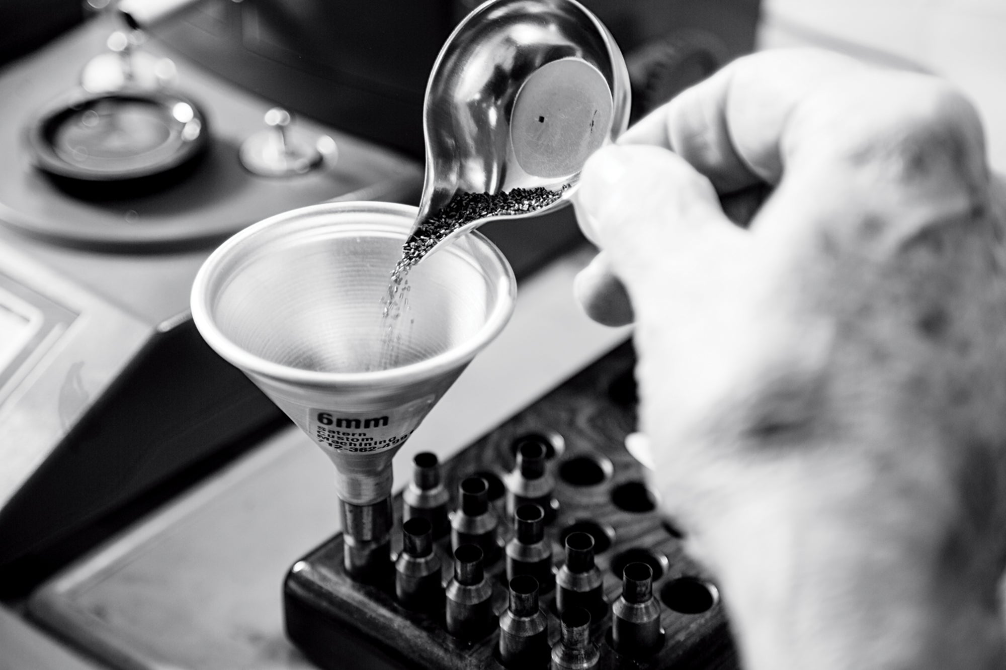 Pouring a powder charge while hand loading.