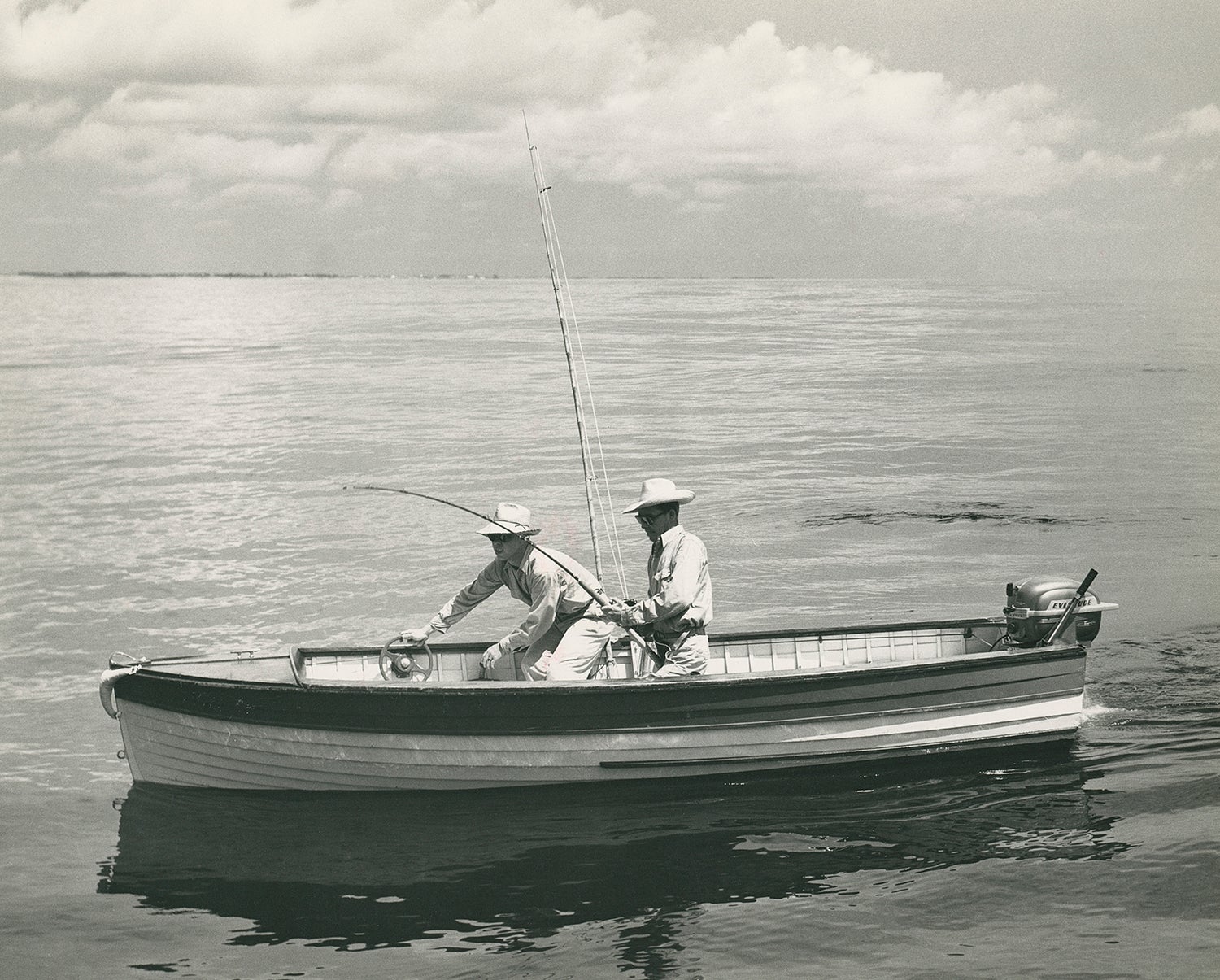 two anglers in boat on big water, one steering from front of boat