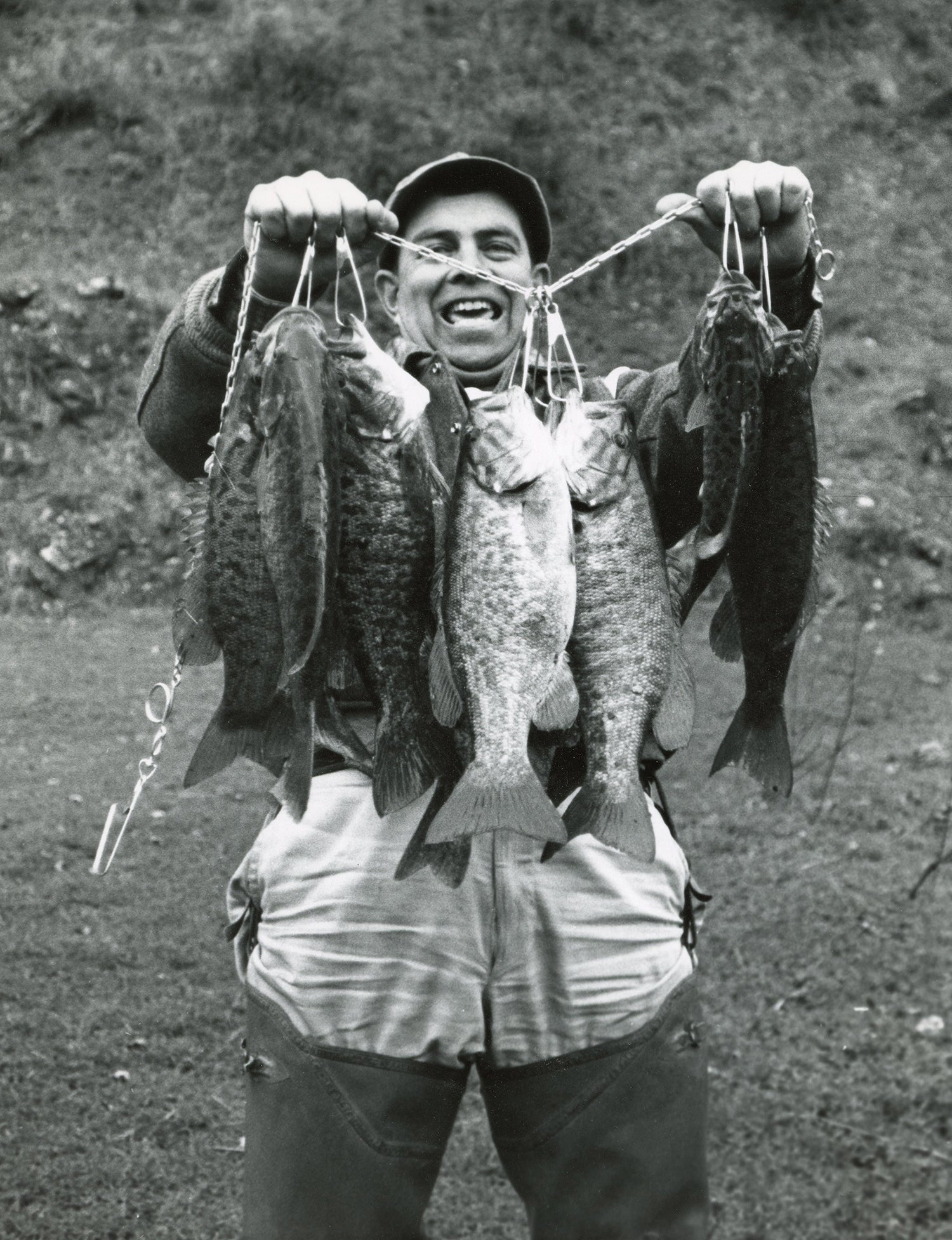 angler holds up big chain stringer of good-size smallmouth bass