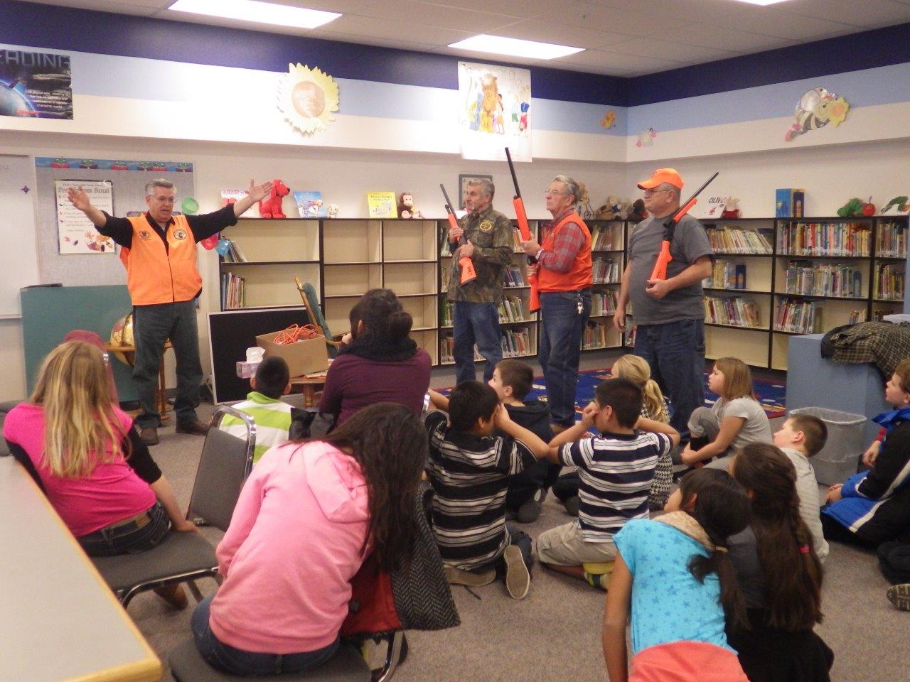 Hunter safety instructors teach a class of kids.