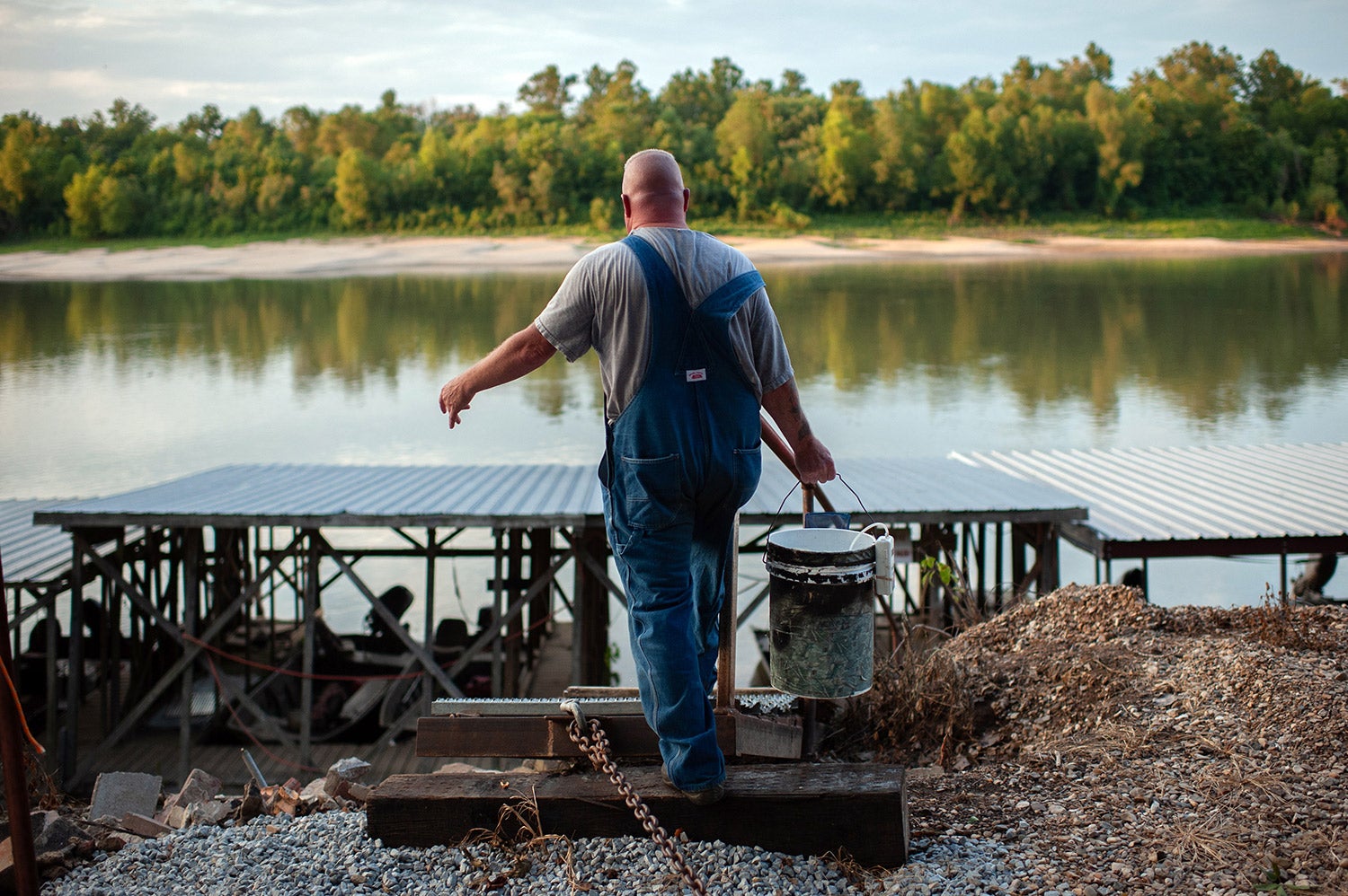 trotliner with bucket walks towards river and docks