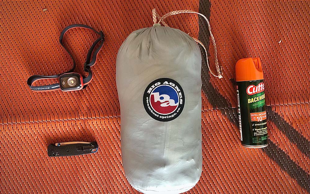 A headlamp, pocket knife, sleeping bag, and bugspray