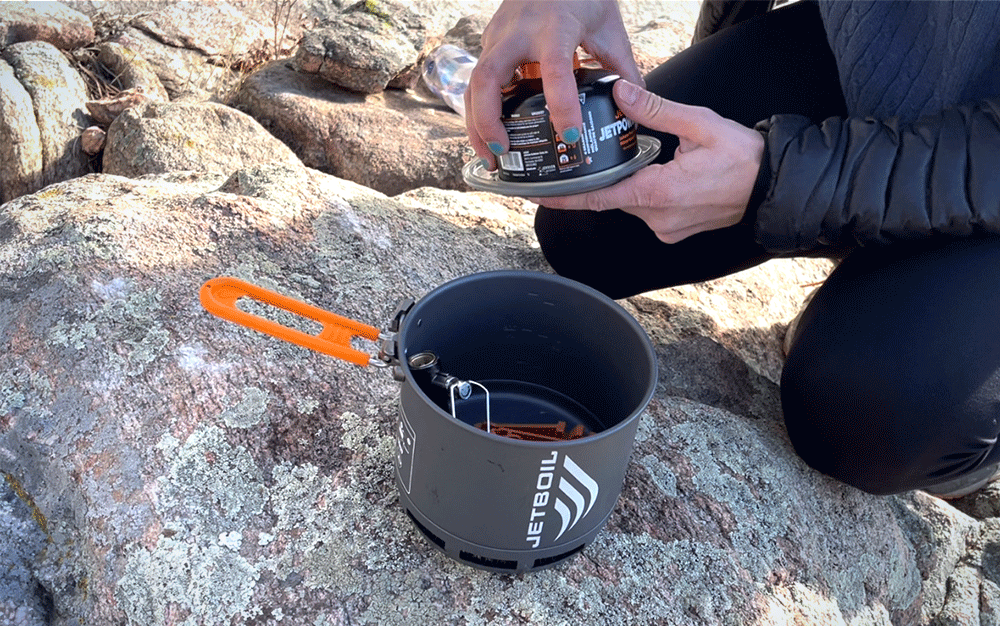Someone packing up fuel into a small pot