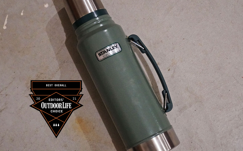 A green Stanley thermos with a handle and a silver top