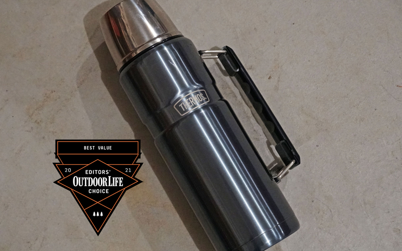 A blue Thermos with a handle and silver cap