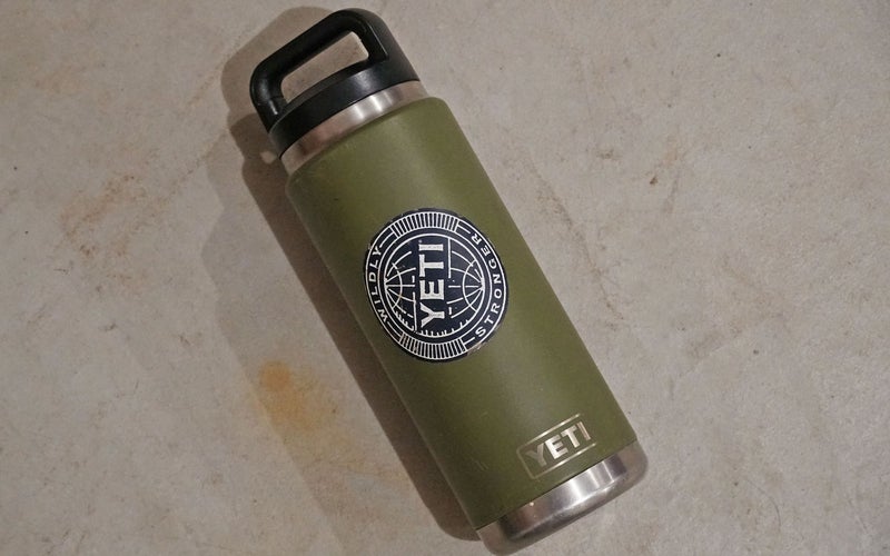 A green YETI Rambler thermos with a black cap