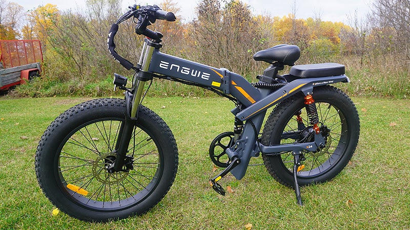 The gray and black Engwe X24 folding fat tire bike sitting on a grassy lawn.