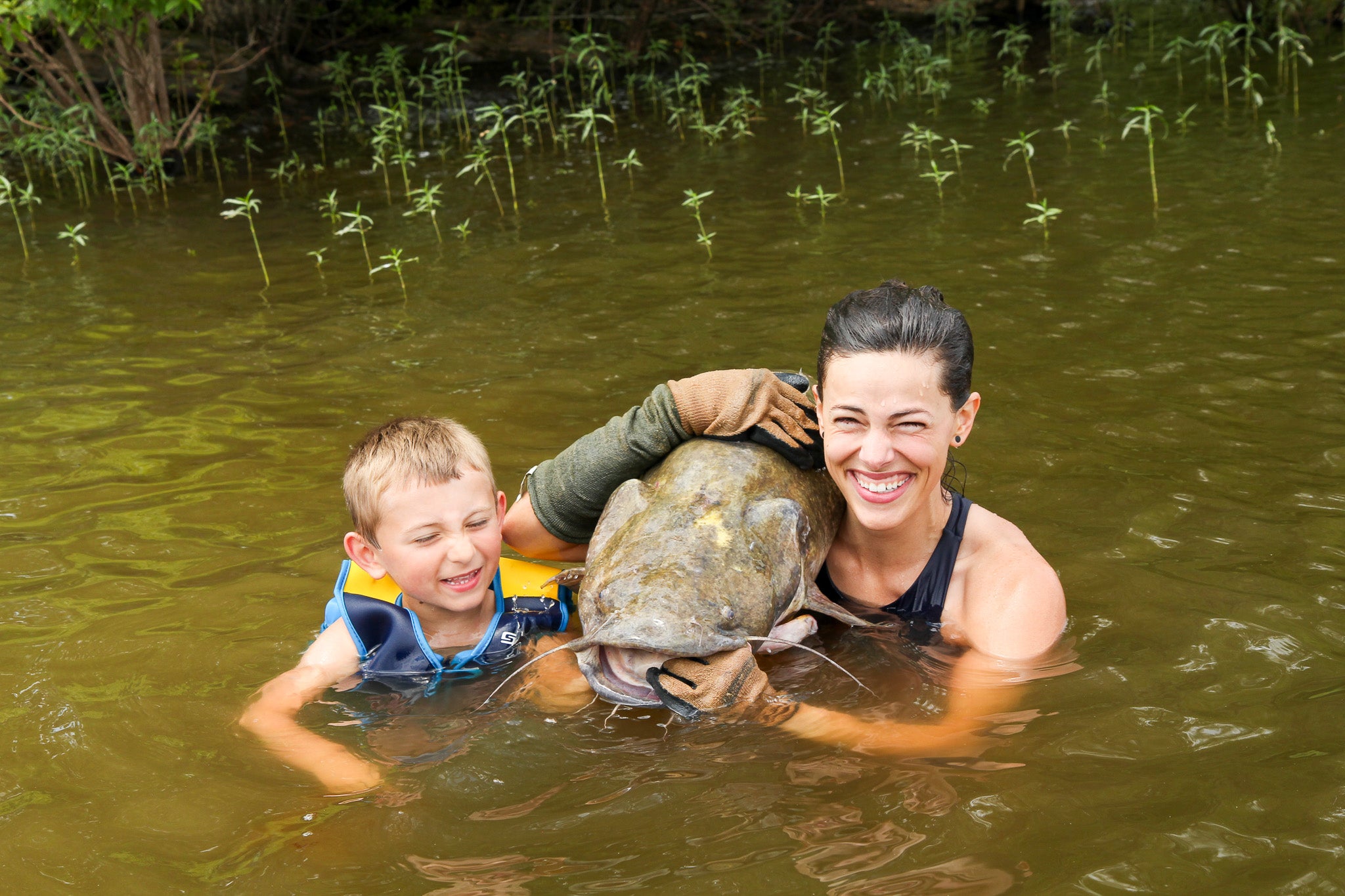 Supporting a catfish over a shoulder.