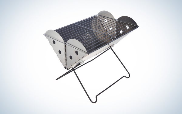 The silver folding UCO flatpack grill on a black and white gradient background.