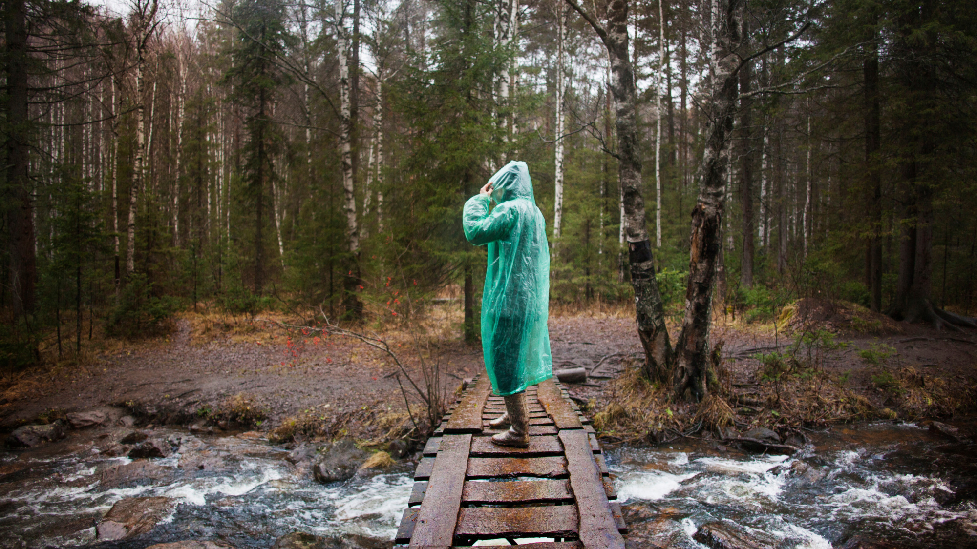 woman in rain poncho on bridge