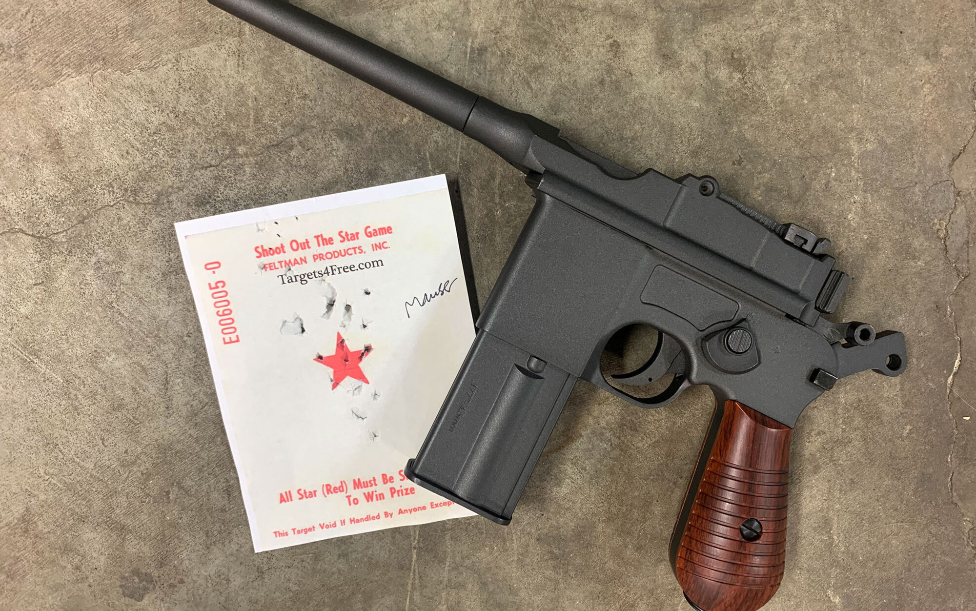 The Umarex Legends Mauser M712 sits with target.