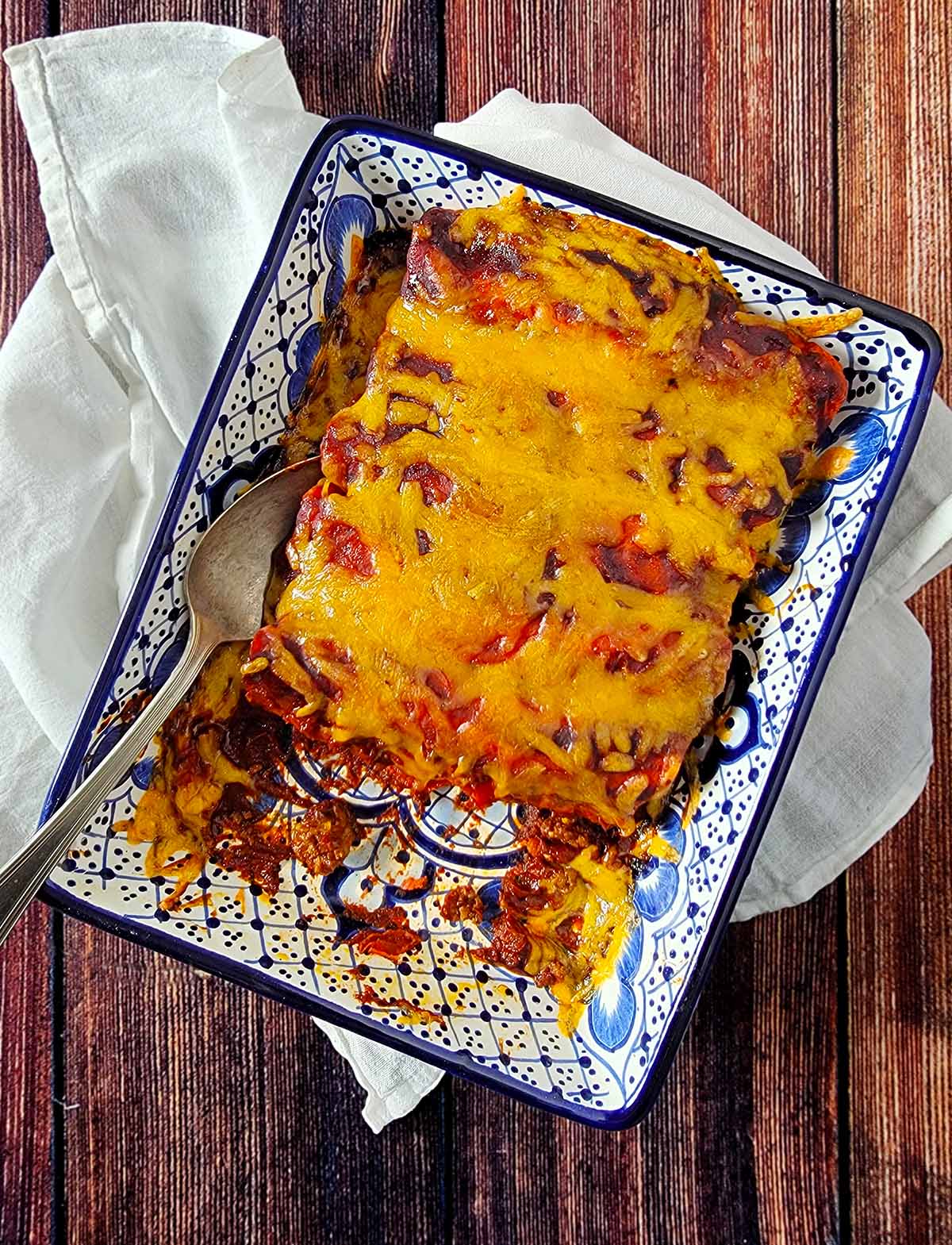 A dish of venison enchiladas, with two taken out. 